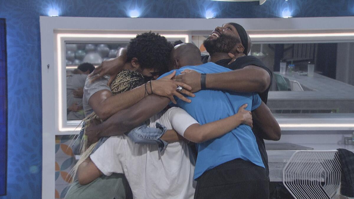Reality show contestants in a group hug