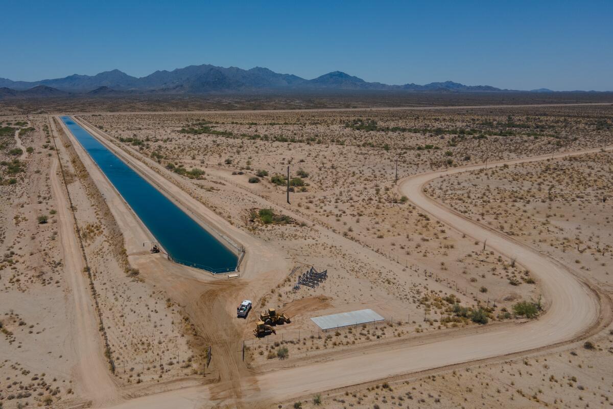 A water truck pulls into a road next to a Central Arizona Project canal near the Fondomonte farm in Butler Valley