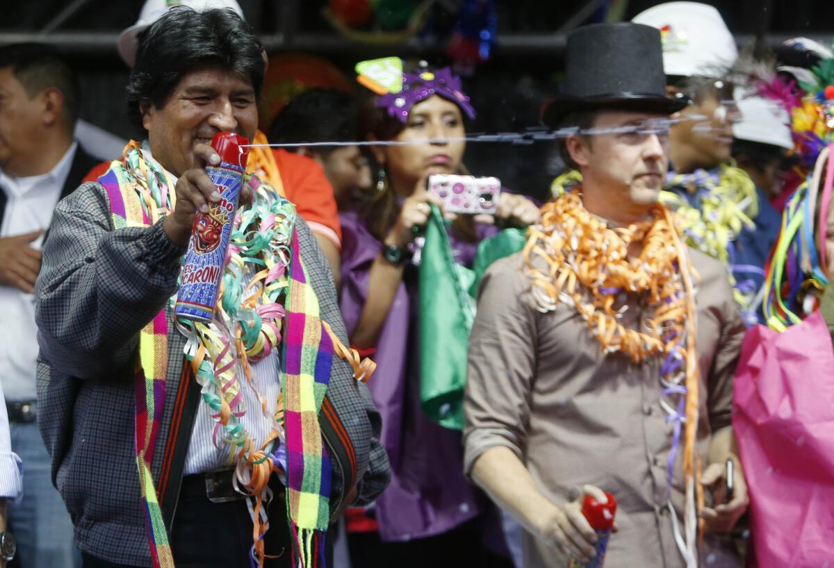 El presidente boliviano Evo Morales lanza espuma en los festejos de Carnaval frente al palacio de gobierno en La Paz, Bolivia, 5 de febrero de 2016. (AP Foto/Juan Karita)