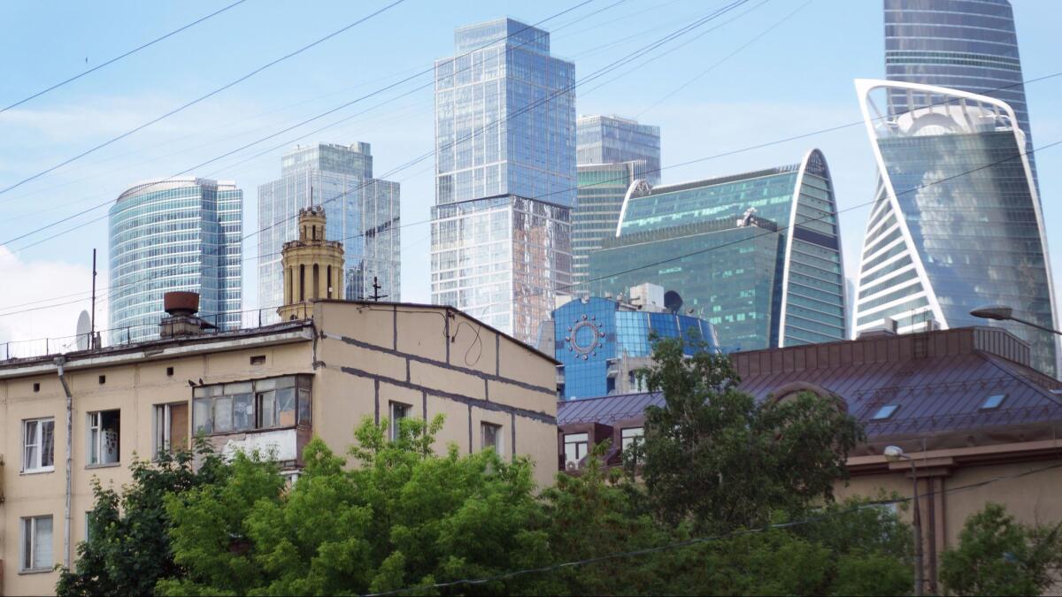 A controversial plan to knock down Soviet-era apartment blocks, like these dwarfed by modern skyscrapers, has led to an outcry, with many Moscow residents saying the program is a ploy to funnel state funds into construction companies.