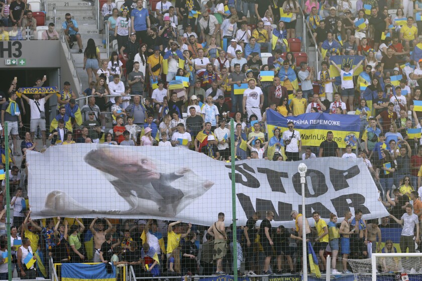Aficionados de Ucrania despliegan una bandera contra la guerra durante un partido de la Liga 