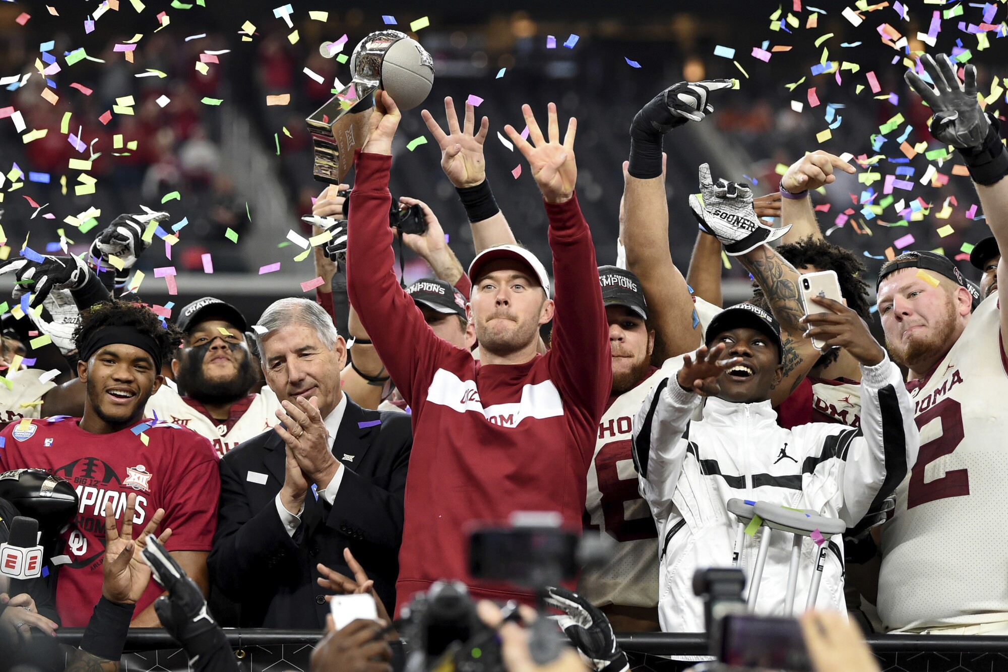 Oklahoma coach Lincoln Riley holds up the Big 12 championship trophy after beating Texas in 2018