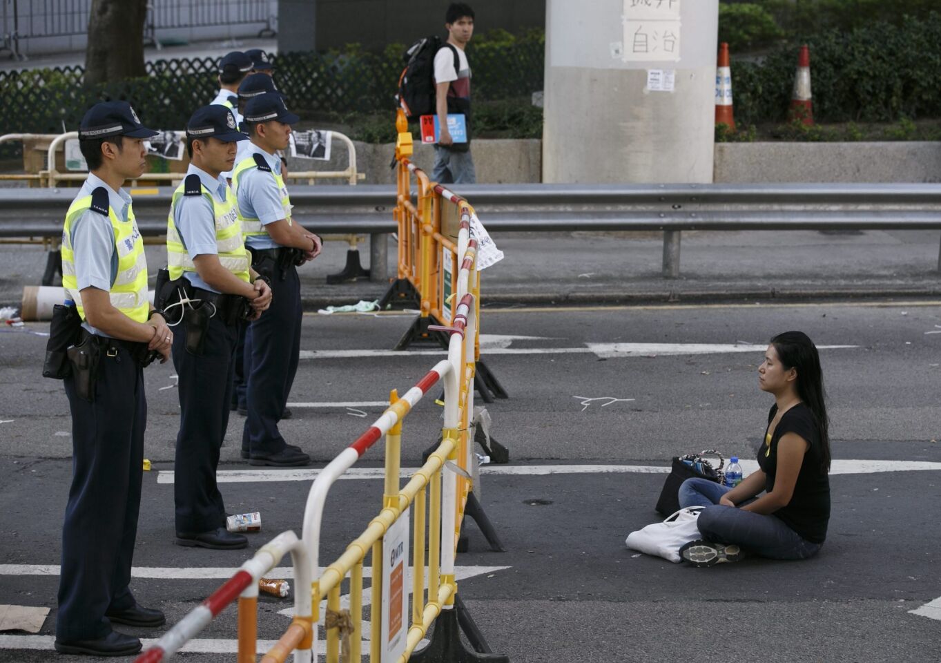 A pro-democracy protester sits in front of Hong Kong police in the Wan Chai area of Hong Kong on Oct. 13.