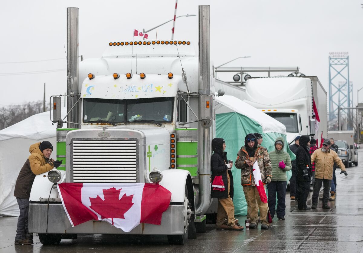 Truckers and supporters block the access leading from the Ambassador Bridge, linking Detroit and Windsor, as truckers and their supporters continue to protest against COVID-19 vaccine mandates and restrictions, in Windsor, Ontario, Friday, Feb. 11, 2022. (Nathan Denette/The Canadian Press via AP)
