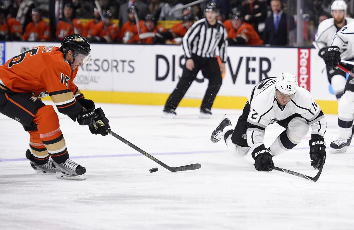 Ducks left wing Ryan Garbutt, left, reaches for the puck along with Kings right wing Marian Gaborik on Thursday night.