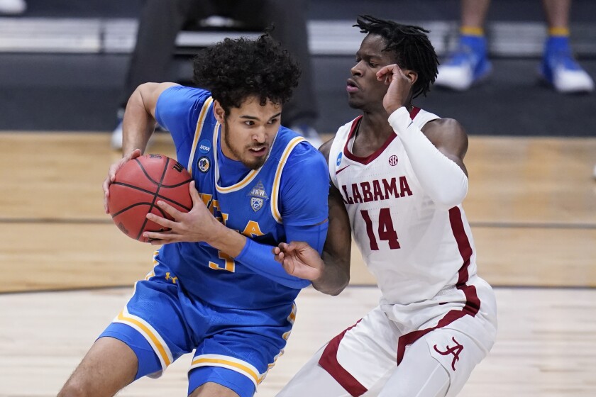 UCLA guard Johnny Juzang drives on Alabama guard Keon Ellis.