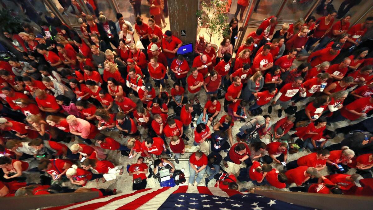 Teachers crowd the lobby of the Arizona Senate as lawmakers debate a budget Thursday in Phoenix.