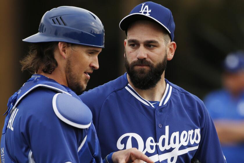 Los Angeles Dodgers' Yasmani Grandal, left, speaks with Chris Hatcher during the team's first pitchers and catchers workout on Feb. 20, 2015, in Phoenix.