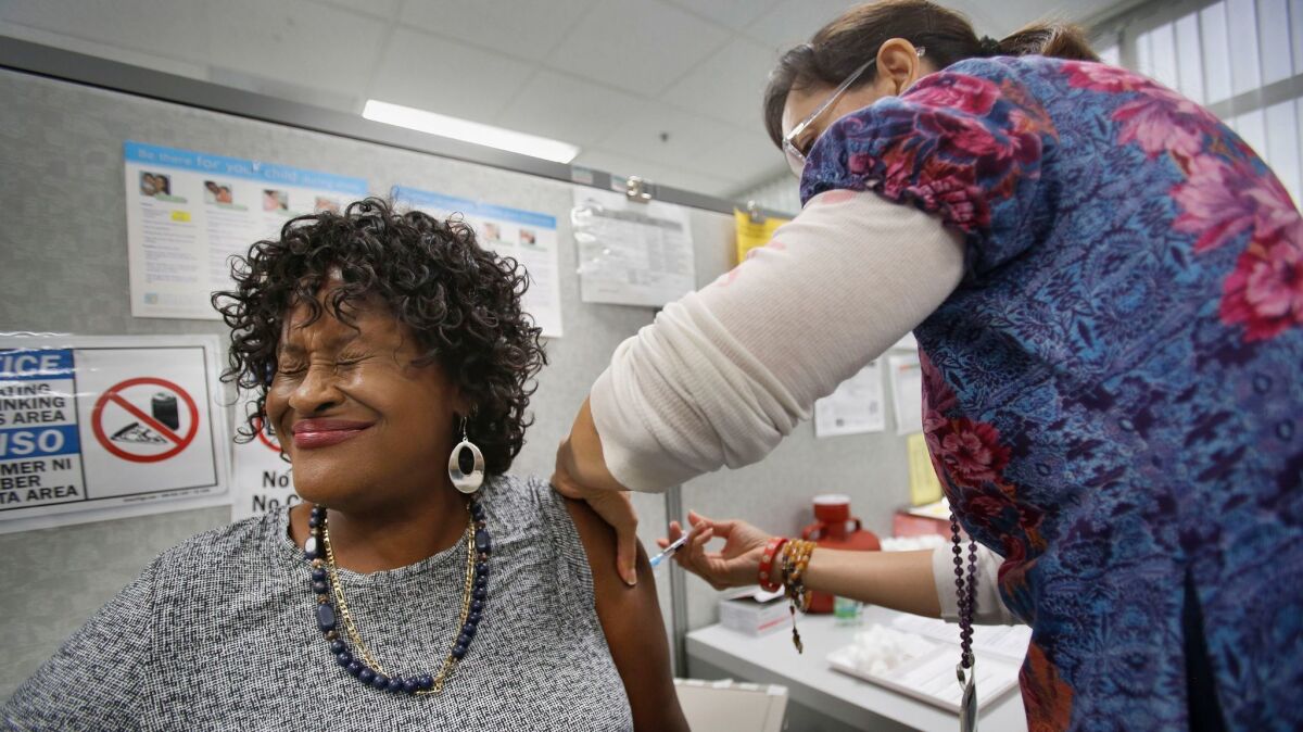 Judy Starks of La Mesa winces as San Diego County Public Health Nurse Rosalinda Ruezga gives her the first of a two-part hepatitis A vaccination.