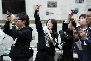 Staff of Japan Aerospace Exploration Agency (JAXA) watch a live streaming of the pinpoint moon landing operation by the Smart Lander for Investigating Moon (SLIM) spacecraft observe a live streaming at JAXA's Sagamihara Campus Saturday, Jan. 20, 2024, in Sagamihara near Tokyo. Japan's space agency said early Saturday that its spacecraft is on the moon, but is still "checking its status." More details will be given at a news conference, officials said. (AP Photo/Eugene Hoshiko)