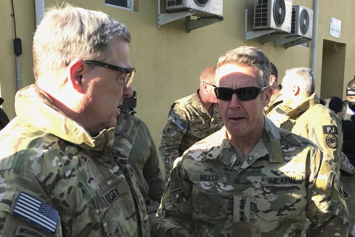 FILE - In this Dec. 16, 2020, file photo Chairman of the U.S. Joint Chiefs of Staff Gen. Mark Milley, left, talks with Gen. Scott Miller, the commander of U.S. and coalition forces in Afghanistan at Miller's military headquarters in Kabul, Afghanistan. The U.S. military will remain involved in the Afghanistan war into September, keeping the option of launching airstrikes against the Taliban to defend Afghan forces, U.S. officials said Thursday, July 1. For weeks, officials have said the withdrawal of the main U.S. military force and its equipment from Afghanistan would be largely completed by this weekend. Miller, the top U.S. commander there, would then leave, marking a significant turning point in the U.S. mission. (AP Photo/Robert Burns, File)