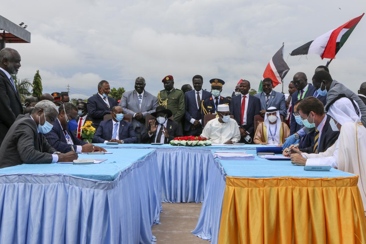 The head of Sudan's sovereign council, Gen. Abdel-Fattah Burhan, seated center-left, President of South Sudan Salva Kiir, seated center, and President of Chad Idriss Deby, seated center-right, attend a ceremony to sign a peace deal between Sudan's transitional authorities and a rebel alliance, in Juba, South Sudan, Saturday, Oct. 3, 2020. Sudan's transitional authorities and a rebel alliance on Saturday signed the peace deal initialed in August that aims to put an end to the country's decades-long civil wars, in a televised ceremony in Juba, South Sudan marking the agreement. (AP Photo/Maura Ajak)