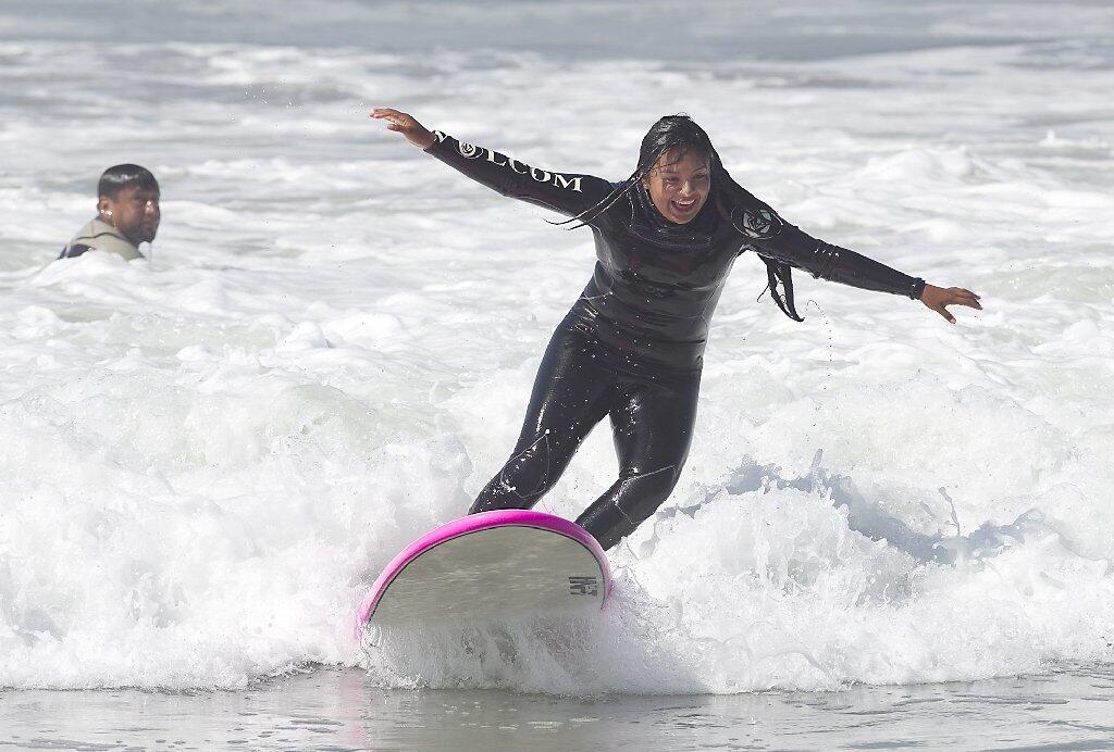 Jackie Olivares gets to her feet during Save Our Youth’s Surf Days program in west Newport on Thursday.