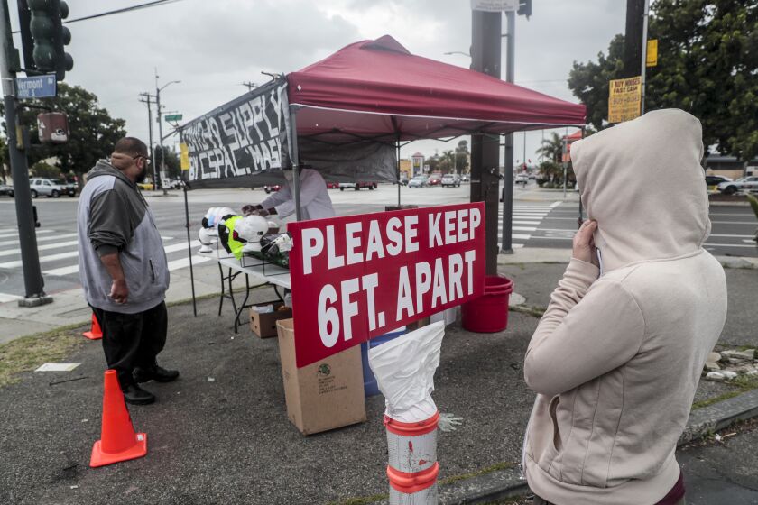 GARDENA, CA - APRIL 07: A street corner vendor sells masks. Prices range from two to ten dollars at the corner of Rosecrans and Vermont Ave on Tuesday, April 7, 2020 in Gardena, CA. (Robert Gauthier / Los Angeles Times)