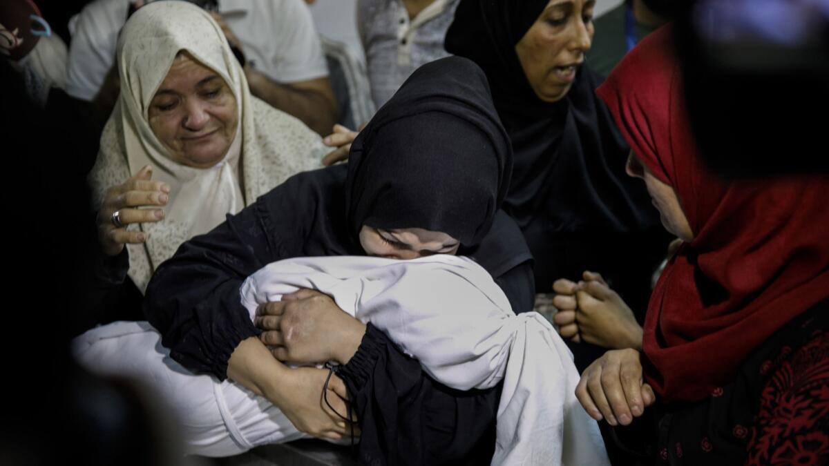 Mariam Ghandour, 18, holds the body of her daughter, Layla.