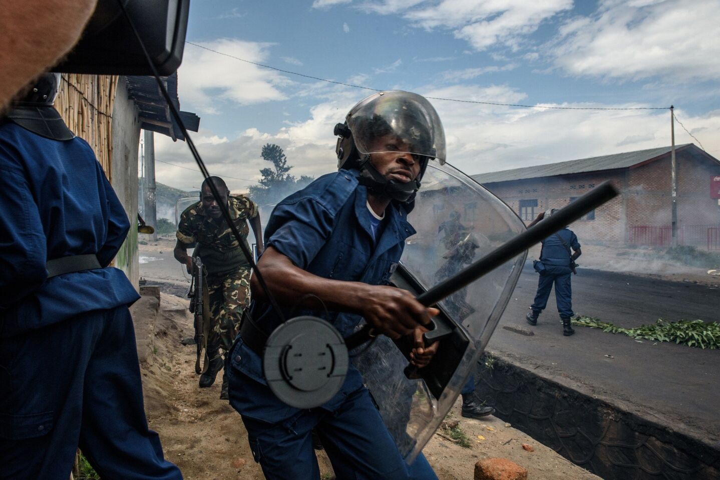 Police and soldiers run after protesters who were throwing rocks in Bujumbura, Burundi.