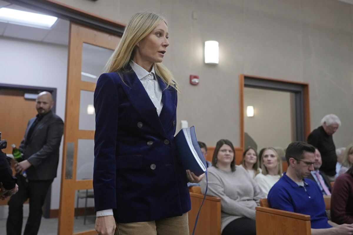Gwyneth Paltrow enters a courtroom wearing a blue jacket and white collared shirt