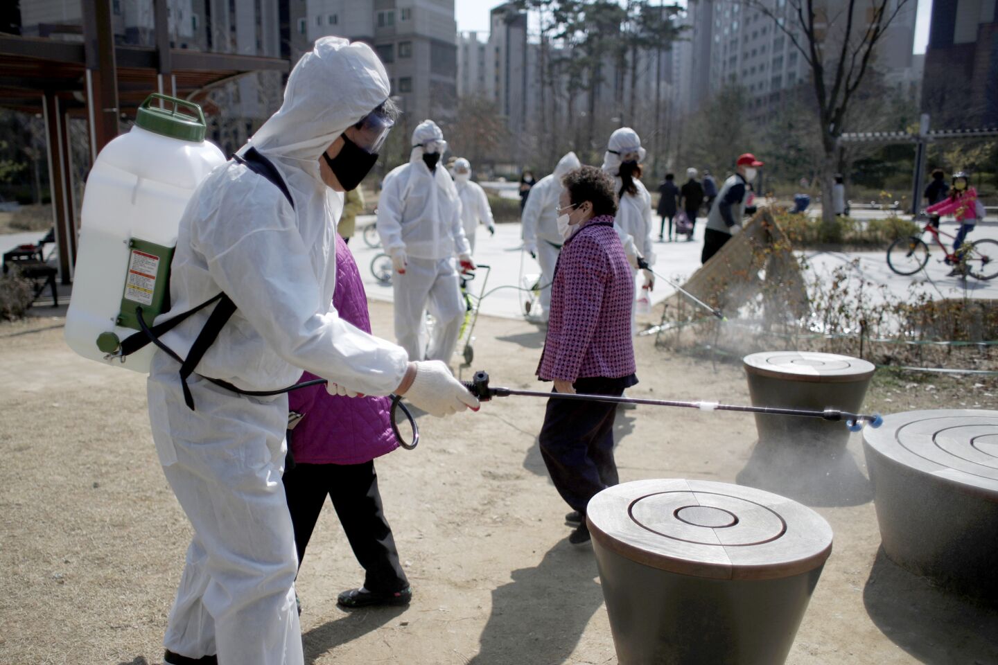 South Korea: Members of a local residents group wear protective gear as they disinfect a local park as a precaution against the new coronavirus in Seoul.