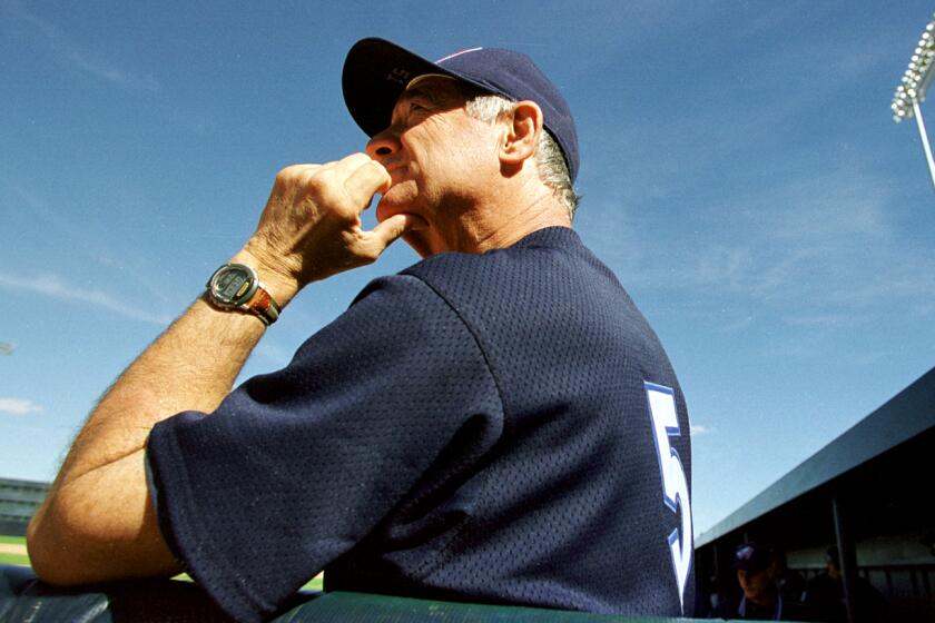 Angels coach Sam Suplizio watches from the dugout as the Angels take on the Oakland Athletics in 1998.