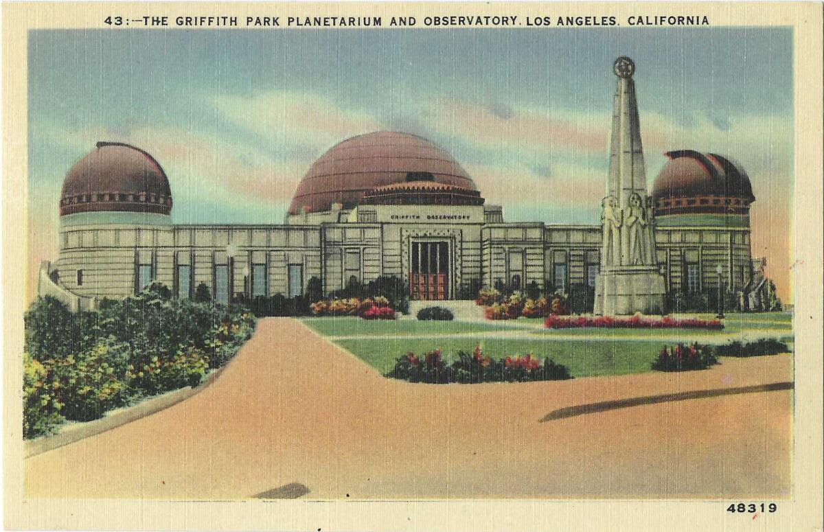 The three round domes of an observatory with a statue in front of the building.