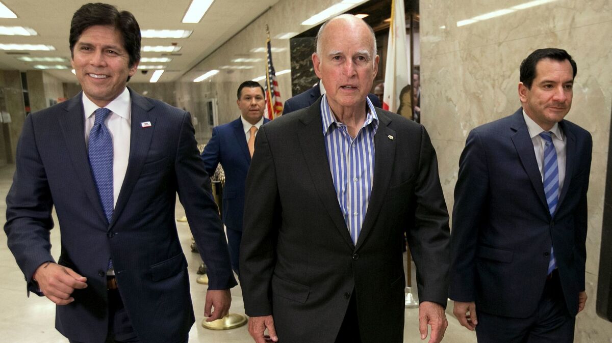 State Senate President Pro Tem Kevin de León (D-Los Angeles), left, Gov. Jerry Brown and Assembly Speaker Anthony Rendon (D-Paramount), right, head to a Capitol news conference to discuss the passage of a pair of climate change bills in July.