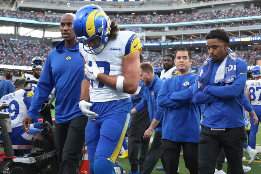 Rams receiver Puka Nacua is helped from the field after suffering an injury in the second quarter.