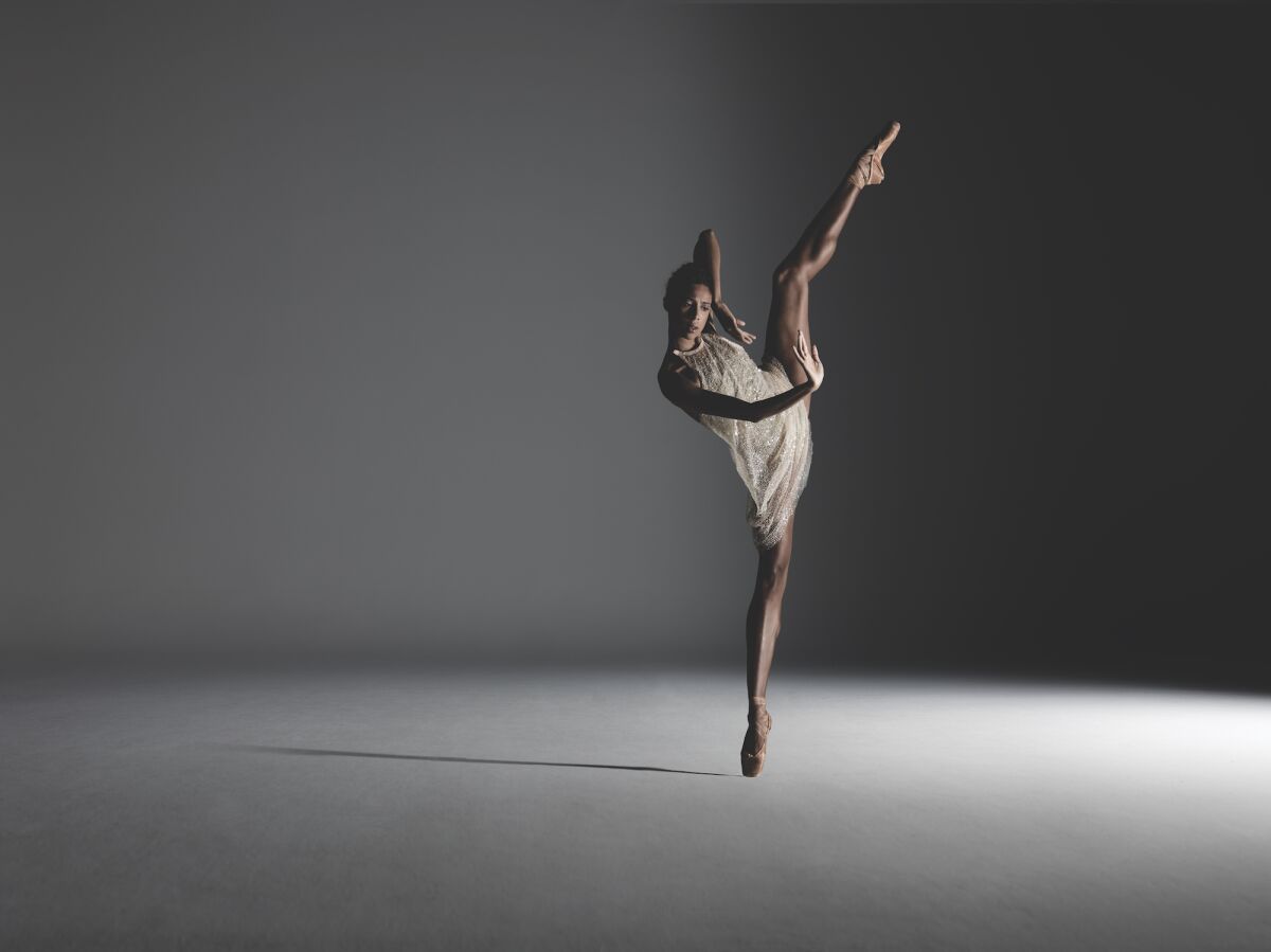 Dancer Adji Cissoko standing on pointe with one leg raised in the air