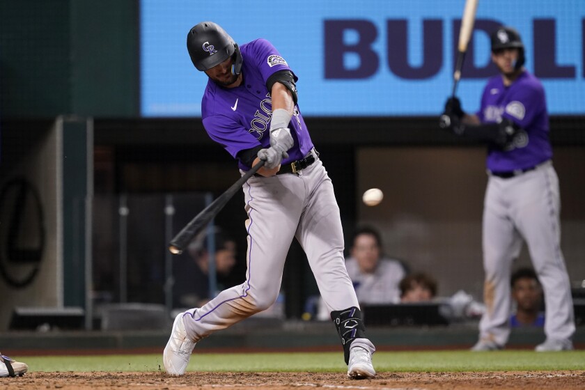 Colorado Rockies' Kris Bryant connects for a sacrifice fly that scored Connor Joe in the seventh inning of a baseball game against the Texas Rangers, Tuesday, April 12, 2022, in Arlington, Texas. (AP Photo/Tony Gutierrez)
