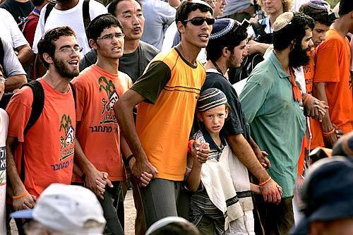 Residents and supporters in the settlement of Neve Dekalim stand in force near the main entrance to prevent police from entering to deliver evacuation notices.