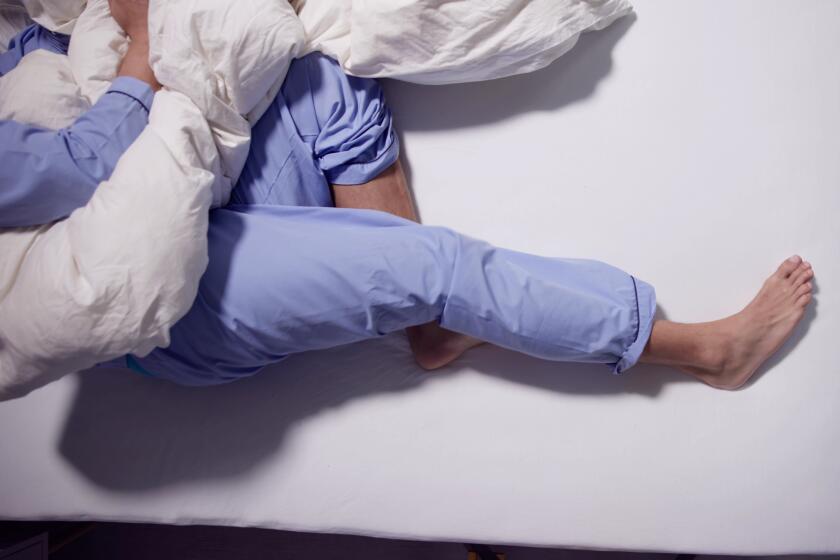 Man With RLS - Restless Legs Syndrome. Sleeping In Bed