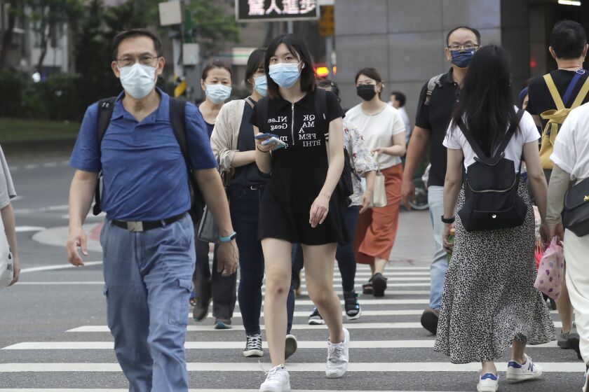 People wear face masks to help protect against the spread of the coronavirus in Taipei, Taiwan