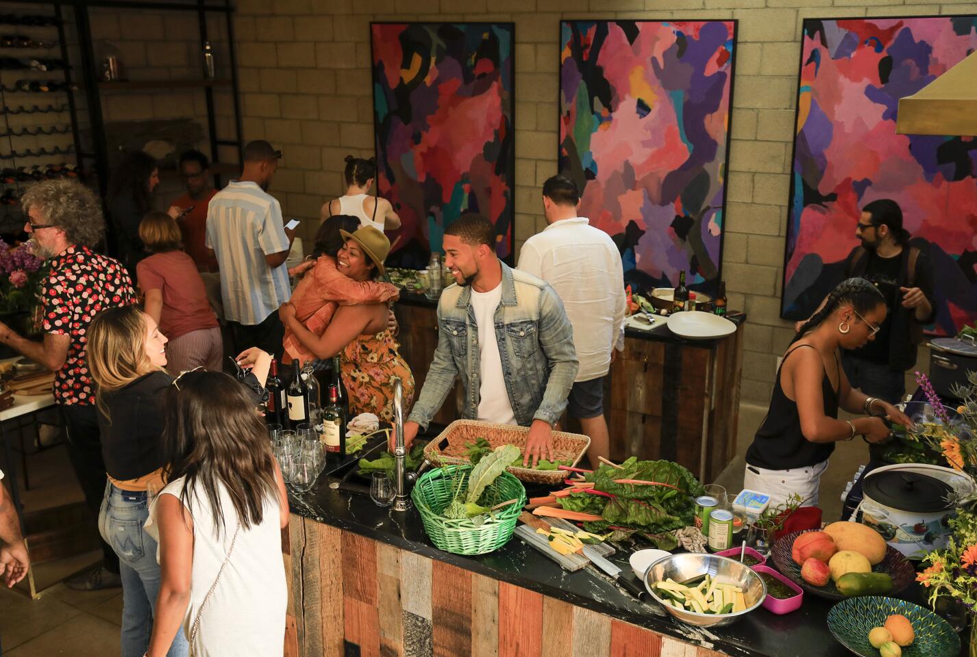 LOS ANGELES, CA., JUNE 9, 2019: The kitchen in Doctors Diego and Resa Caivano's home is buzzing with activity while everyone helps to prepare the Sunday dinner June 9, 2019. The fresh vegetables came from their rooftop garden. The Caivanos love having dinner with their friends so much that it has become a tradition in their hillside Silver Lake home. On any given Sunday as many as 30-50 people are fed grilled delights from their outdoor pizza oven and grill and vegetarian dishes mixed with the fellowship of friends and neighbors. Designed by architect Brooks Atwood, the home reflects the funky, stylish, intelligence of the owners with a nod to practical, natural elements like an edible rooftop garden and a pool that is filtered by plants