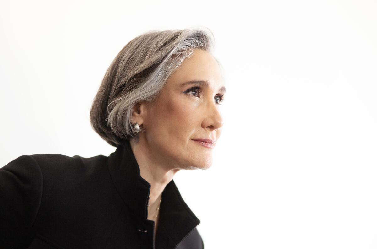 A profile shot of a woman with gray hair in a black top.