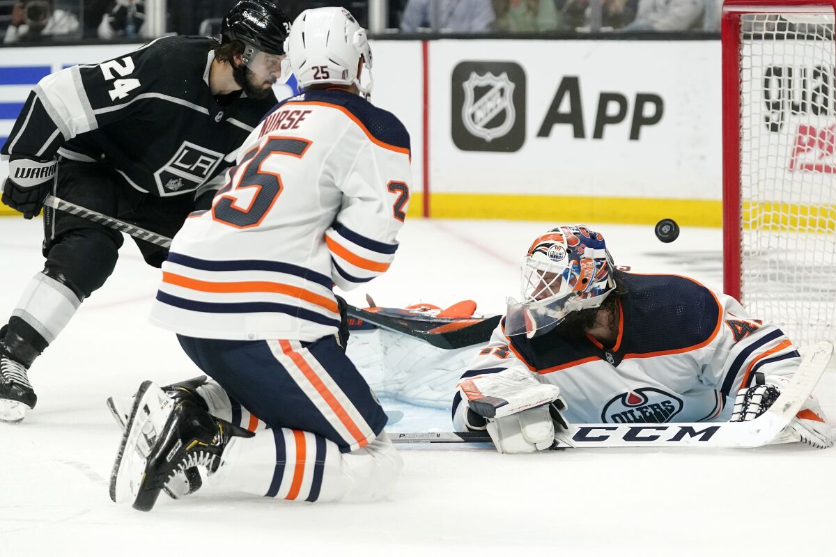 Los Angeles Kings center Phillip Danault, left, scores on Edmonton Oilers goaltender Mike Smith, right, as defenseman Darnell Nurse watches during the second period in Game 3 of an NHL hockey Stanley Cup first-round playoff series Friday, May 6, 2022, in Los Angeles. (AP Photo/Mark J. Terrill)