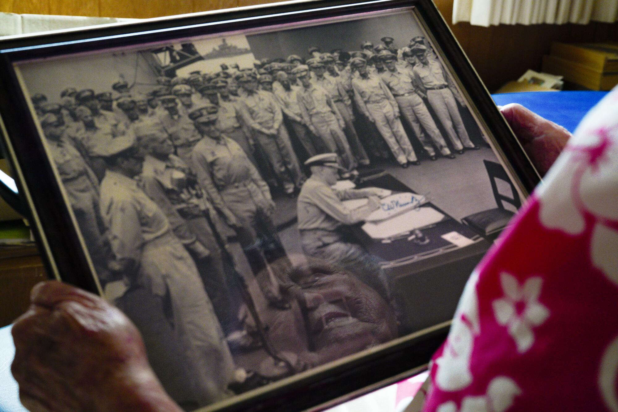 Joedy Cronin Adams, 92, looks over the photo of Japan's formal surrender on the deck of the USS Missouri. 