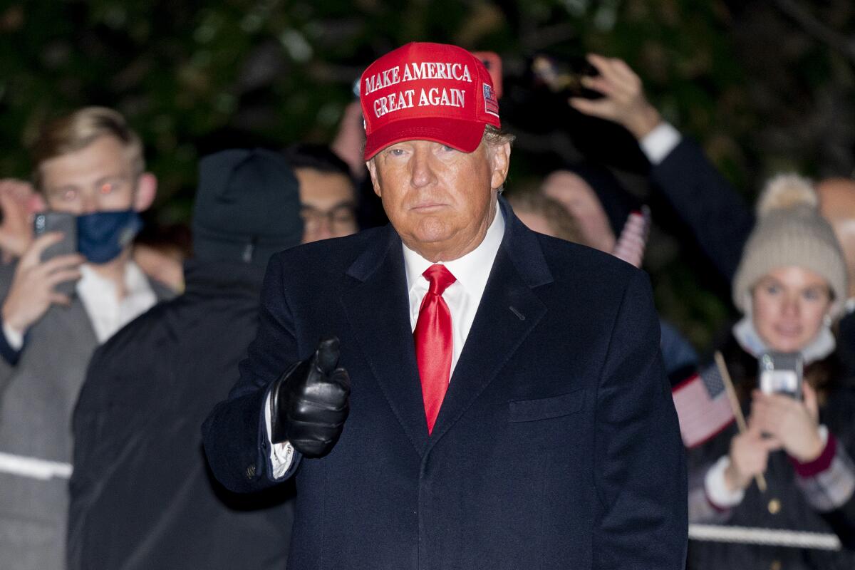 El presidente Donald Trump hace una señal con la mano mientras camina por el jardín sur de la Casa Blanca.