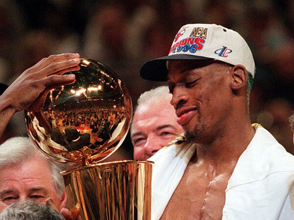 The Chicago Bulls' Dennis Rodman admires the Larry O'Brien NBA Championship Trophy after the Bulls defeated the Seattle SuperSonics to clinch the 1996 NBA title.