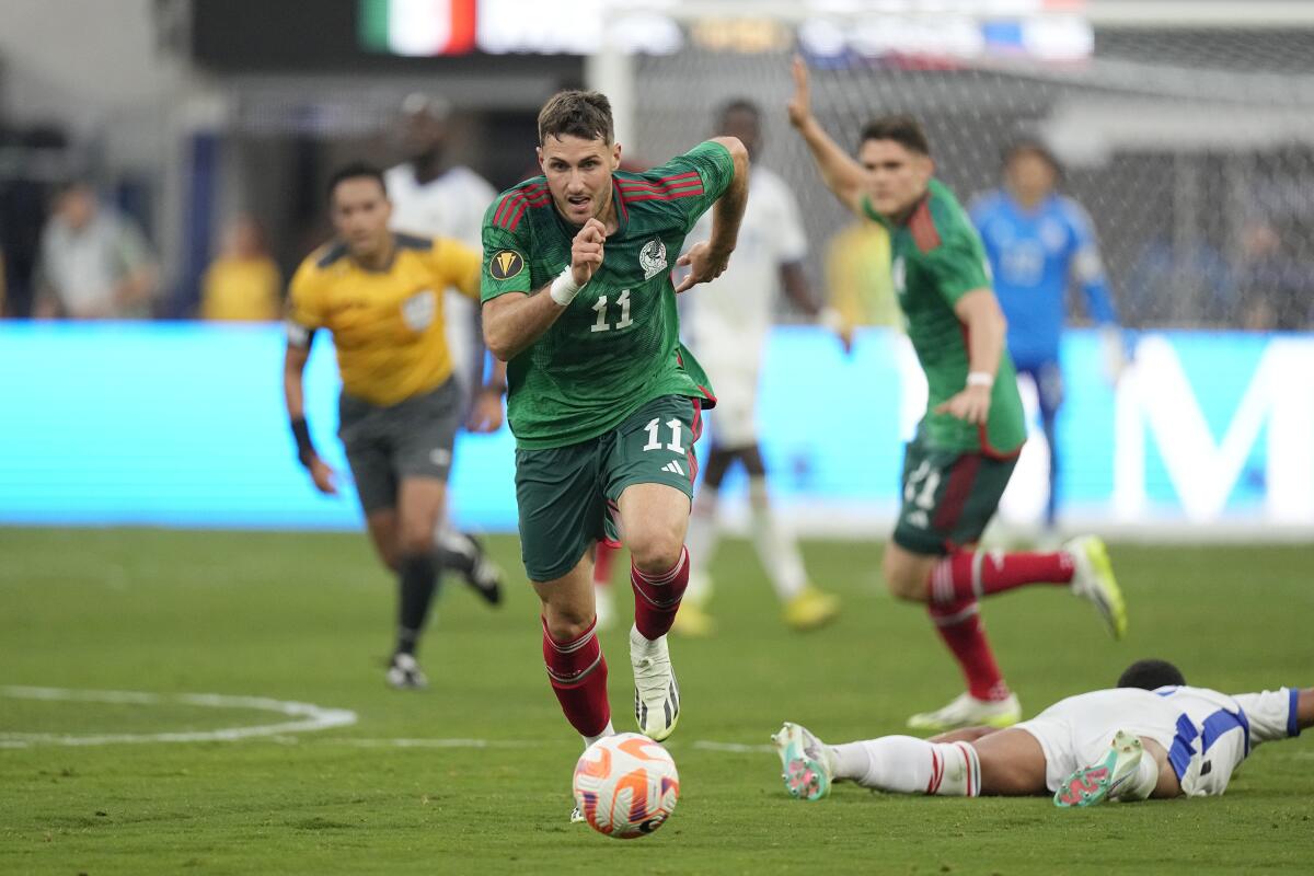 FILE - Mexico's Santiago Gimenez dribbles en route to scoring a