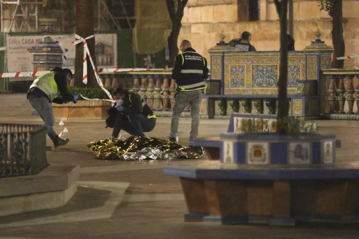 Policías laboran junto al cadáver de un hombre asesinado en Algeciras, España