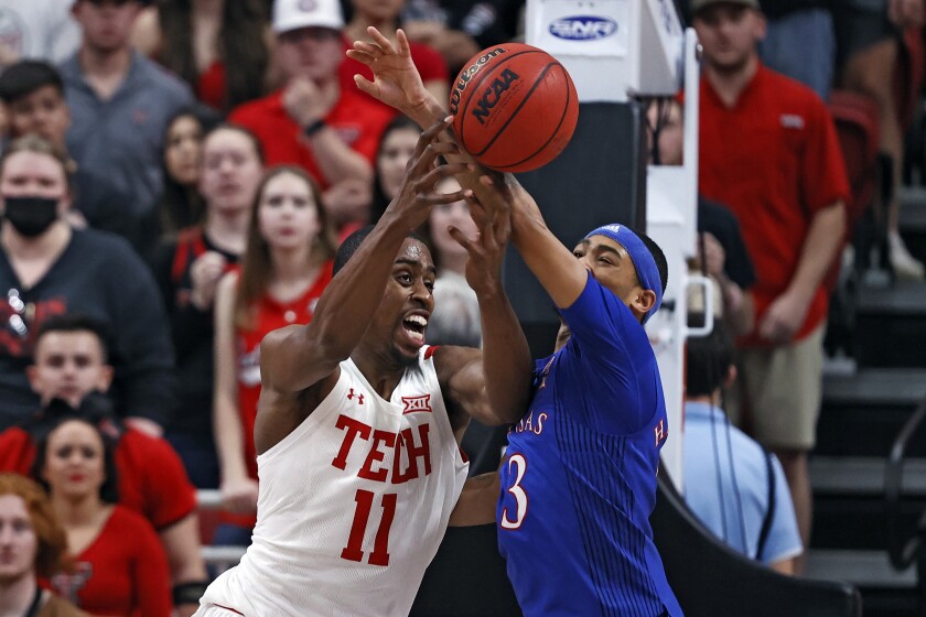 Texas Tech's Bryson Williams (11) and Kansas' Dajuan Harris Jr. (3) fight for control of the ball during the first half of an NCAA college basketball game on Saturday, Jan. 8, 2022, in Lubbock, Texas. (AP Photo/Brad Tollefson)