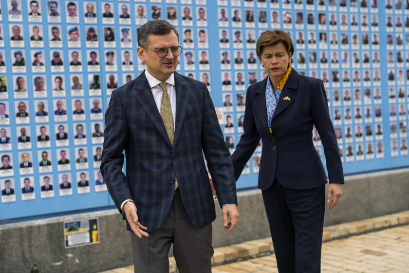 El ministro del Exterior ucraniano Dmytro Kuleba, y su contraparte letona Baiba Braze parten luego de colocar flores en el muro que recuerda a los soldados ucranianos muertos en guerra, en la catedral de San Miguel, Kiev, viernes 26 de abril de 2024. (AP Foto/Francisco Seco)