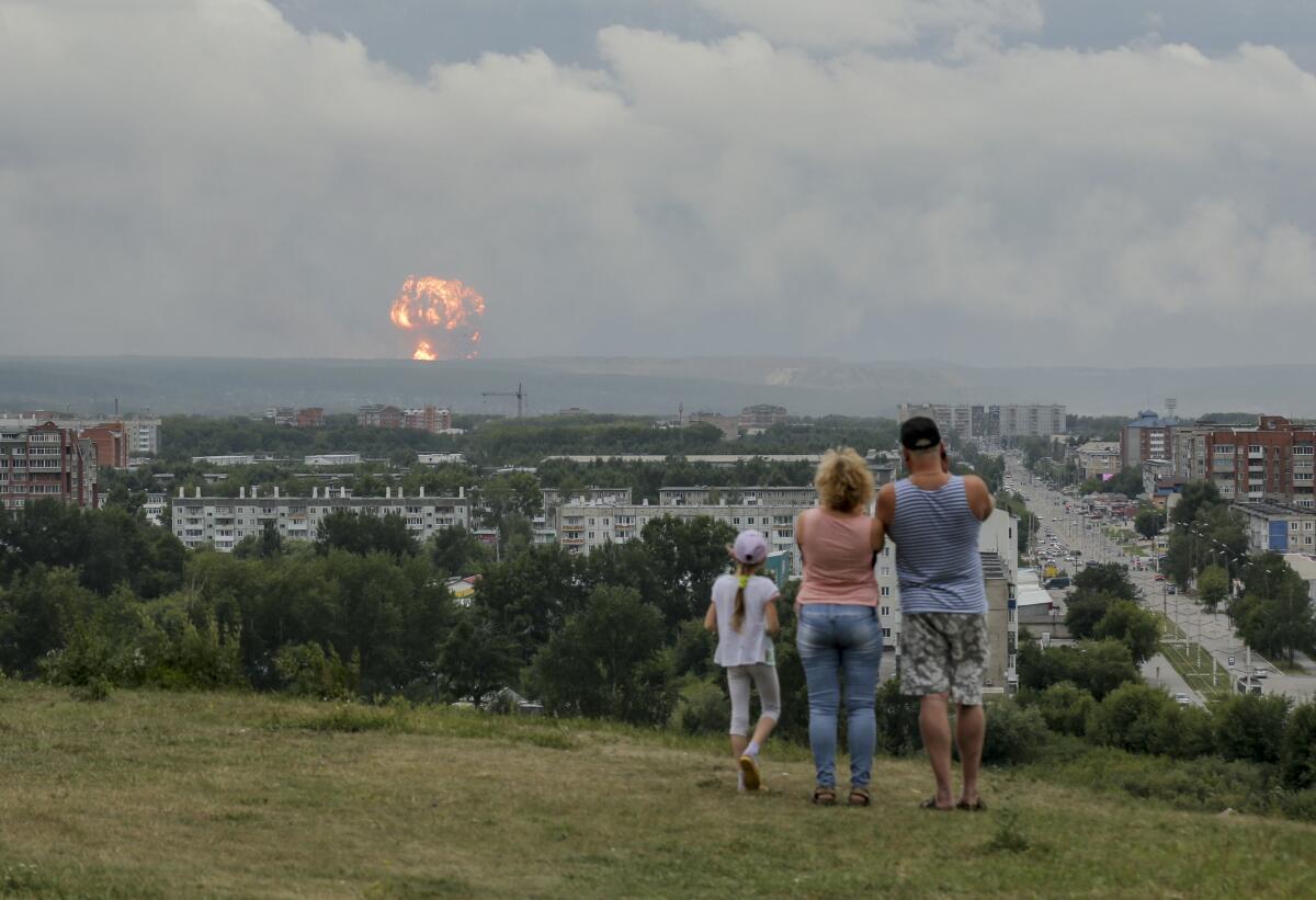 A family watches explosions in Achinsk, Russia
