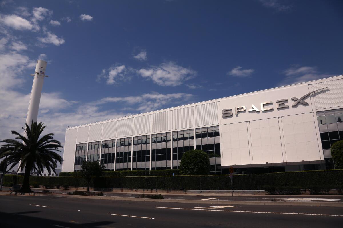 A white rectangular building with a sign that says SpaceX
