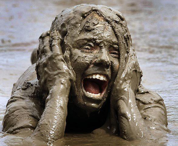 Alyssa Braun, 12, of Canton, Mich., comes up smiling at Mud Day in Westland, Mich., Tuesday. The sloppy annual celebration is sponsored by the Wayne County Parks Department.