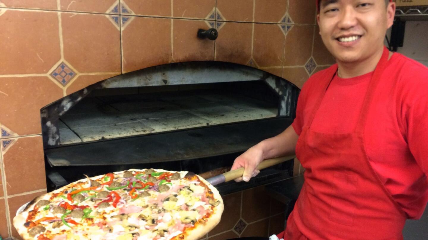 Pulling a pizza from the brick oven at Pavich's.