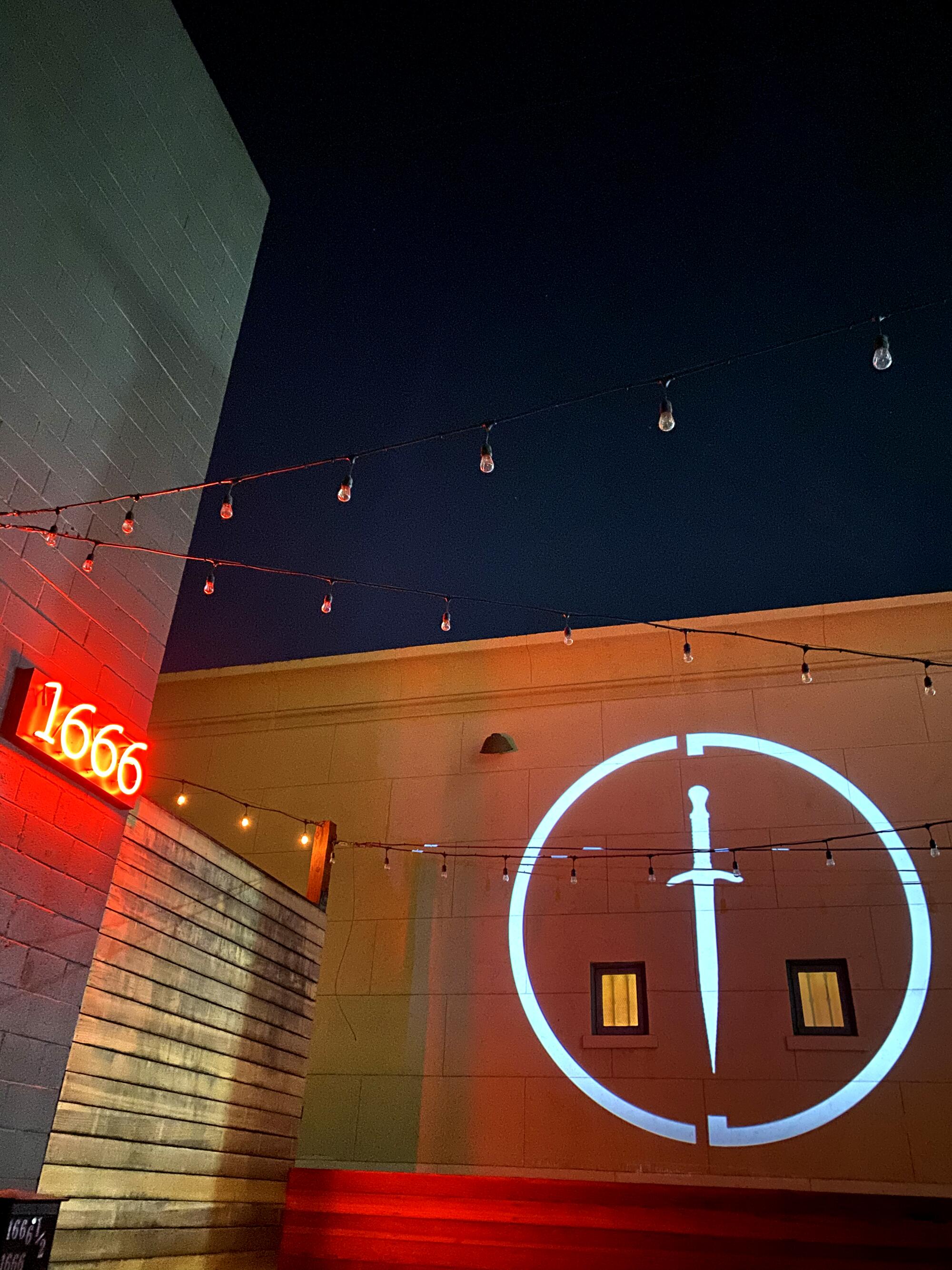 The Cloak & Dagger emblem is projected on a wall outside the club in Hollywood.