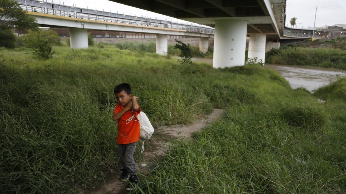 Hassan Bustio Paz, a 5-year-old from Honduras, walks with his mother and other migrants below Puerta Mexico bridge over the Rio Grande in Matamoros, Tamaulipas state, Mexico on June 26.