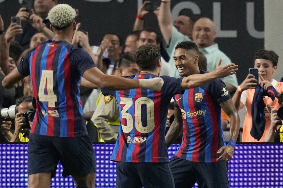 Barcelona's Raphael Dias, right, celebrates after scoring against Real Madrid  