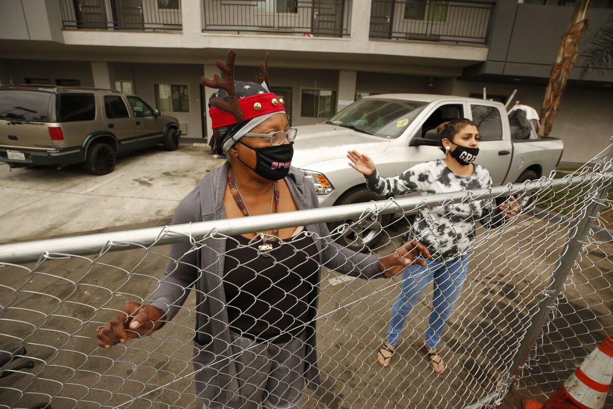 Two women stand behind fencing at a motel.