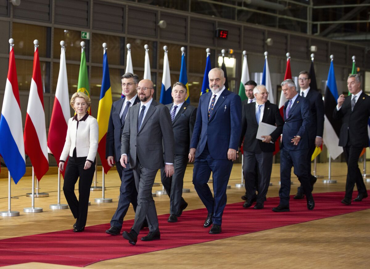 FILE- In this Sunday, Feb. 16, 2020 file photo, European Council President Charles Michel, right front, and European Commission President Ursula von der Leyen, front left, walk with leaders of the Western Balkans prior to a group photo at an EU-Western Balkans meeting at the Europa building in Brussels. The European Union's enlargement policy is at an impasse as its leaders gather for a summit focused on how to deal with Western Balkans neighbors that have been trying to enter the club for two decades. Meanwhile, the region is increasingly getting support from China and Russia instead.(AP Photo/Virginia Mayo, File)